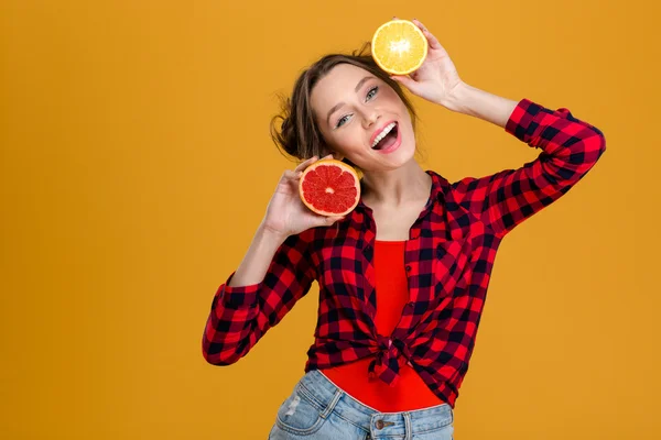 快乐美丽的年轻女子捧着一半的柑橘类水果 — 图库照片