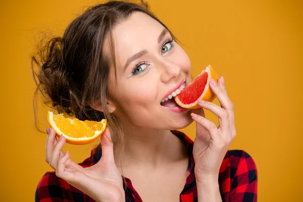 吃柑橘类水果的美丽微笑的年轻女子的画像 — 图库照片