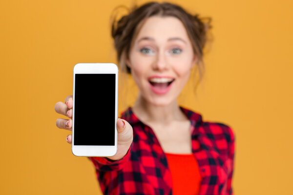 Cheerful woman showing blank smartphone screen 