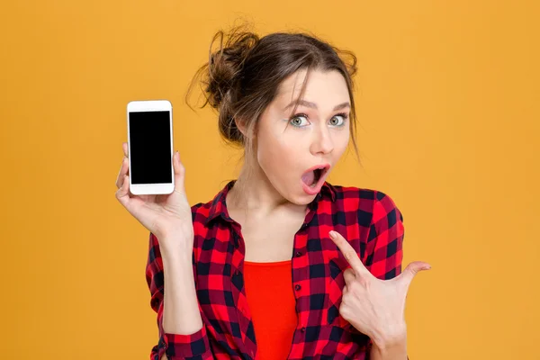 Mujer asombrada mostrando pantalla de teléfono inteligente en blanco — Foto de Stock