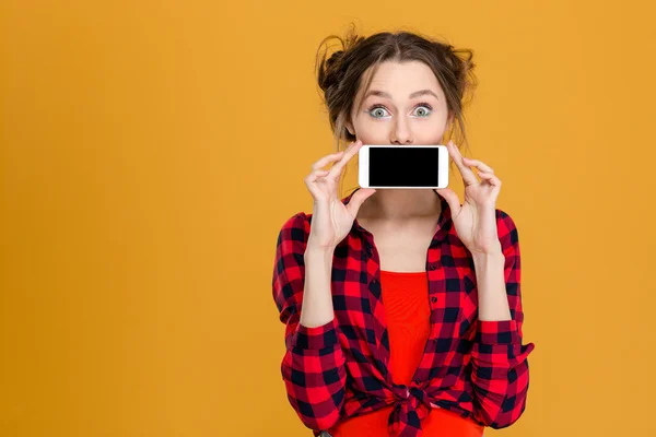 Mulher cobrindo sua boca com tela de smartphone em branco — Fotografia de Stock