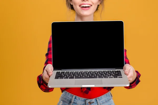 Boş ekran dizüstü bilgisayarı gösteren neşeli sevimli güzel bayanı — Stok fotoğraf