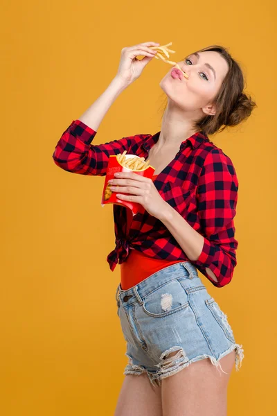 Amüsante komische süße junge Frau, die Spaß mit Pommes hat — Stockfoto