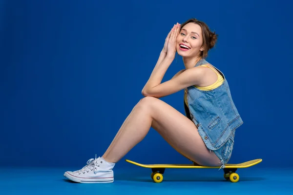 Ευτυχισμένη γυναίκα που κάθεται για skateboard — Φωτογραφία Αρχείου