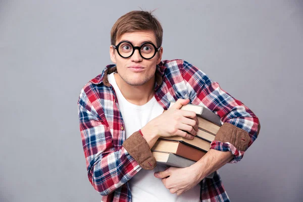 Amusing comical young male in round glasses holding books — Stock Photo, Image