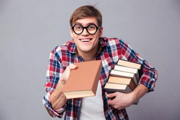 Playful man in funny round glasses giving youn a book — Stock Photo, Image