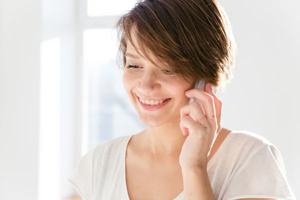 Fechar-se de belo sorrindo jovens usando telefone celular — Fotografia de Stock