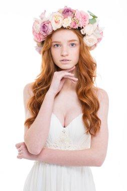 Tender charming woman in wedding dress and wreath of roses 
