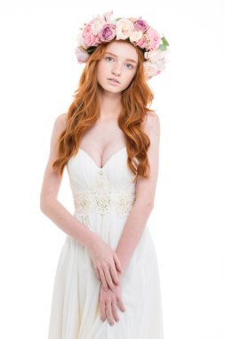 Beautiful young bride in wedding dress and flower wreath 