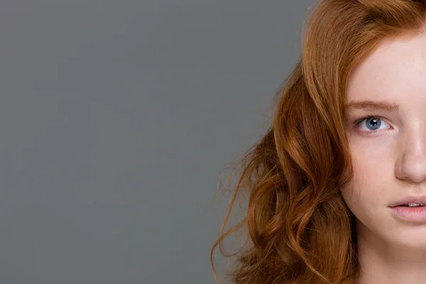 Половина лица рыжеволосой кудряшки с красивыми длинными волосами — стоковое фото