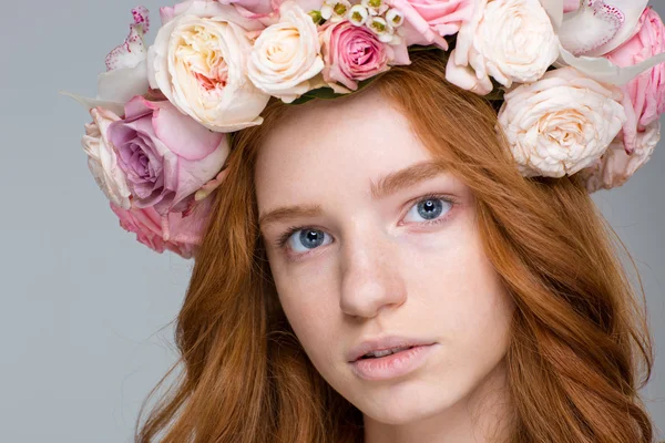 Mulher encantadora com cabelo vermelho na coroa de flores — Fotografia de Stock