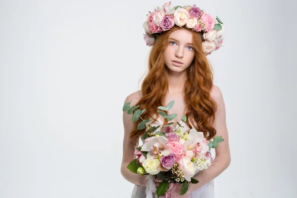 Bonito linda jovem na grinalda com buquê de flores — Fotografia de Stock