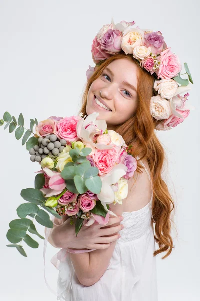 Mujer hermosa feliz en corona de rosas con ramo de flores — Foto de Stock