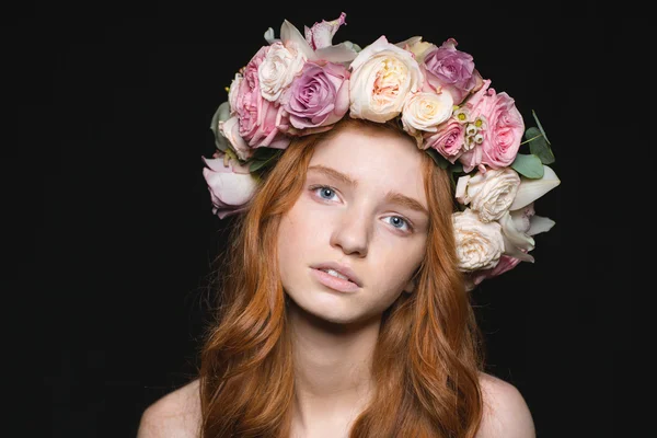 Mulher com grinalda de flores na cabeça olhando para a câmera — Fotografia de Stock