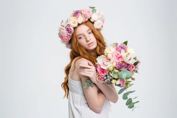 Mulher encantadora macia em grinalda posando com buquê de flores — Fotografia de Stock