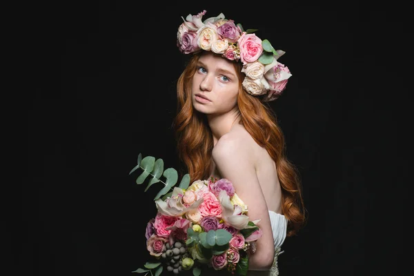 Attraktive rothaarige Frau posiert mit Blumen — Stockfoto