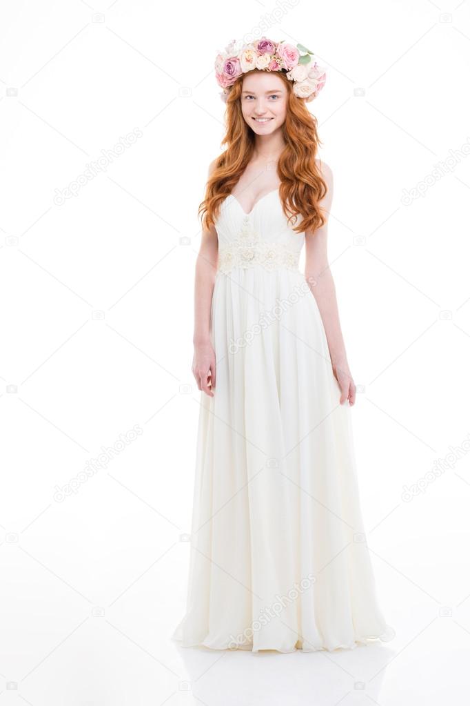 Happy attractive bride in white dress and wreath of roses