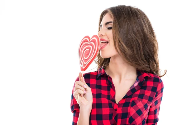 Gros plan de charmante jeune femme mangeant des bonbons en forme de coeur — Photo