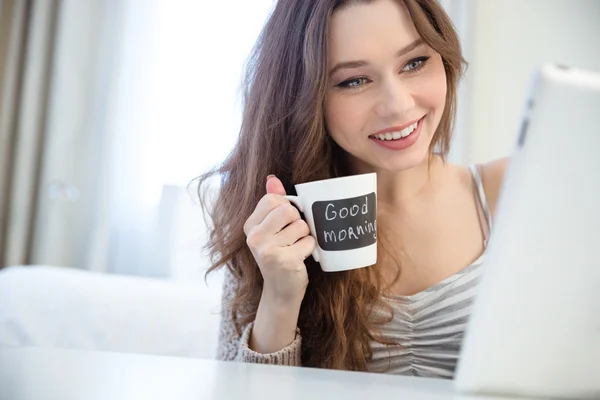 从与黑色区域为写作杯喝咖啡的女人 — 图库照片