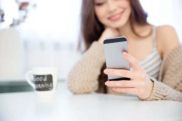 Närbild av mobiltelefon används av glad ung kvinna — Stockfoto