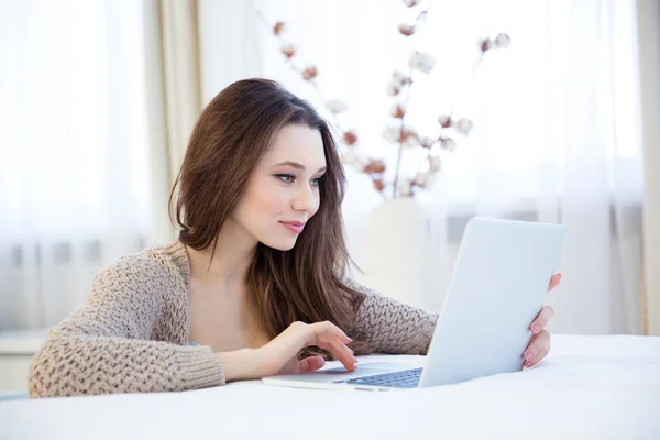 Koncentrerad vacker kvinna med laptop hemma — Stockfoto