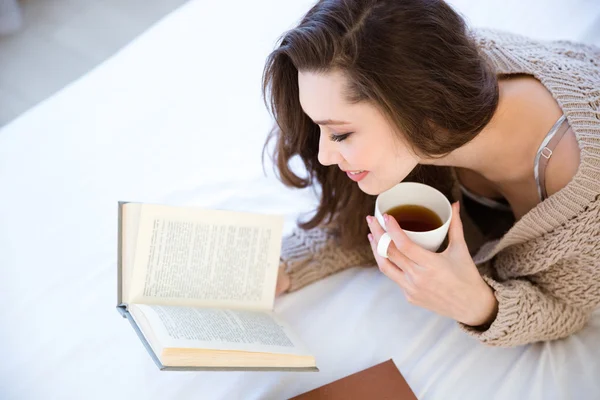 Mooie vrouw lezen van boek en drinken koffie — Stockfoto