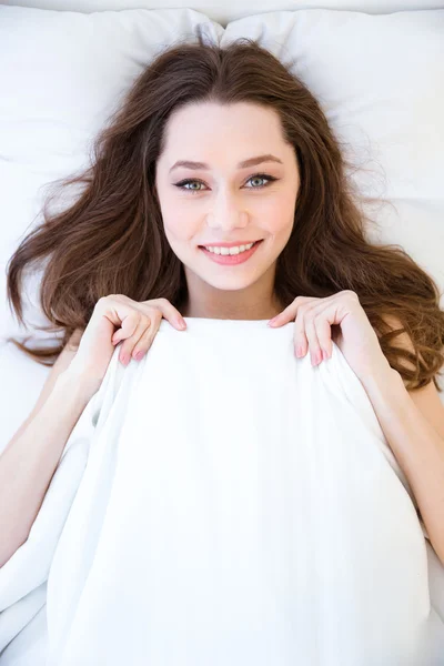 Χαριτωμένος υπέροχη χαμογελαστή νεαρή γυναίκα ξαπλωμένη στο κρεβάτι — Φωτογραφία Αρχείου