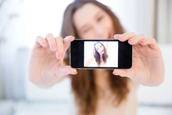 Brincalhão mulher positiva piscando e tirando selfie com smartphone — Fotografia de Stock