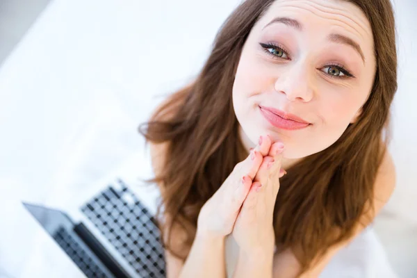 Top view of playful woman begging and using laptop — Stock Photo, Image
