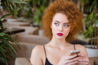 Restoranda smartphone ile masada oturan kadın