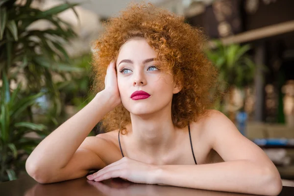 Mujer pensativa sentada a la mesa en el restaurante —  Fotos de Stock