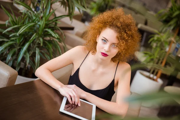 Kobieta siedzi przy stole z komputera typu tablet — Zdjęcie stockowe