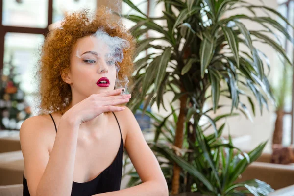 Rothaarige Frau raucht in Restaurant — Stockfoto