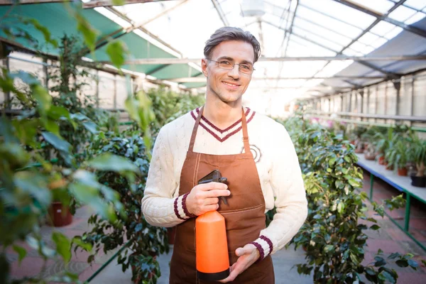 Attractive male gardener standing and holding water pulveriser — 스톡 사진