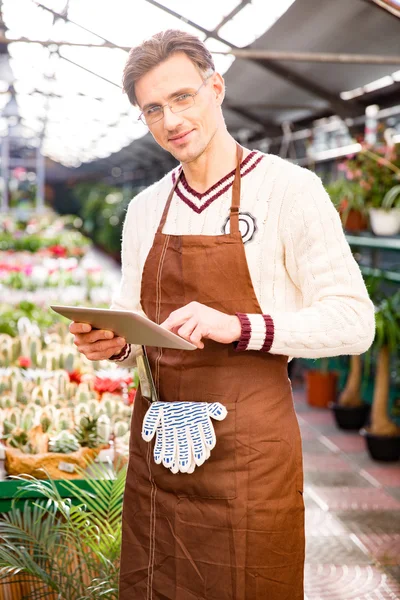 Portrait of male gardener using tablet in orangery — Stockfoto