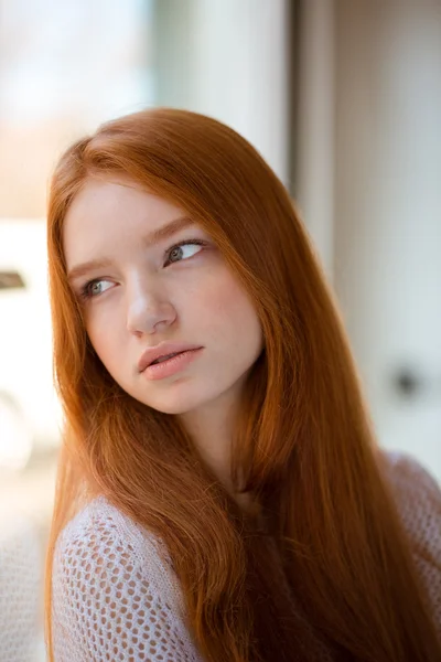 Mulher ruiva olhando para a janela — Fotografia de Stock