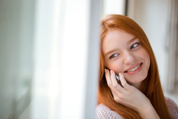 Kobieta rozmawia przez telefon i patrząc na kamery — Zdjęcie stockowe