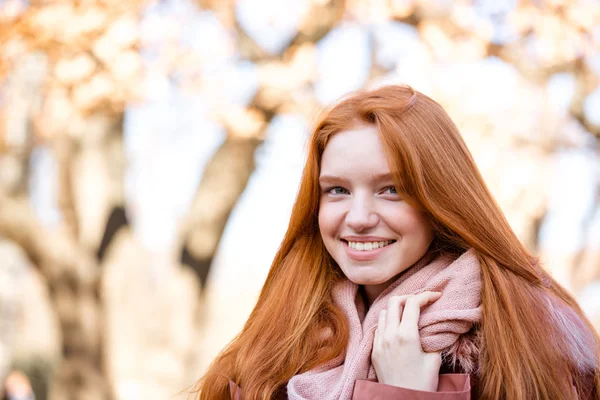 Lächelnde rothaarige Frau, die draußen in die Kamera schaut — Stockfoto