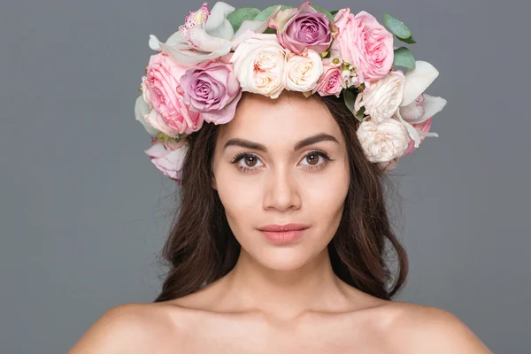 Mulher encantadora com coroa de rosas olhando para a câmera — Fotografia de Stock