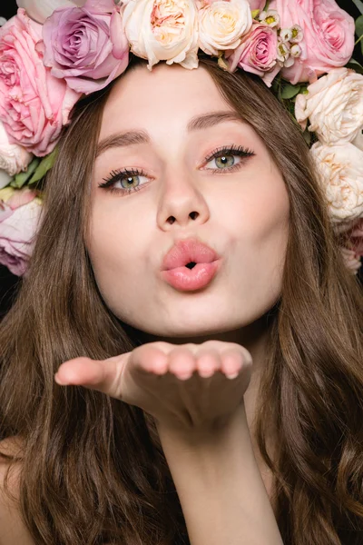 Linda mujer encantadora en hermosa corona de flores enviando un beso —  Fotos de Stock