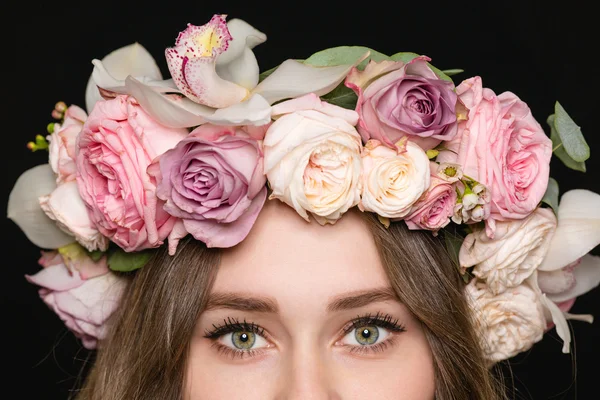 Primer plano de los ojos de la mujer en hermosa corona de rosas — Foto de Stock