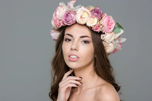 Mujer hermosa con corona de rosas mirando a la cámara —  Fotos de Stock
