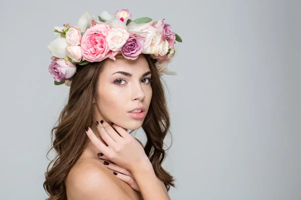 Härlig kvinna med krans från blommor på huvudet — Stockfoto