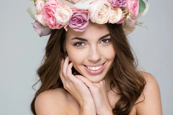 Lachende vrouw met krans van bloemen op hoofd — Stockfoto