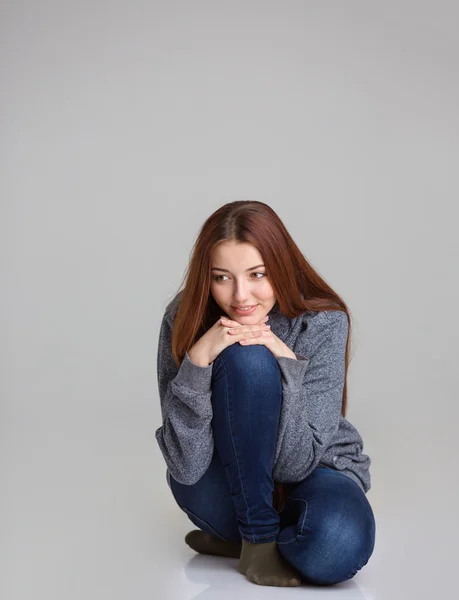 Full length portrait of happy pensive woman sitting and thinking — Stockfoto