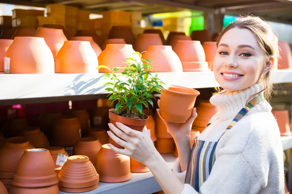 Mujer feliz jardinero comprar nueva olla para la planta — Foto de Stock