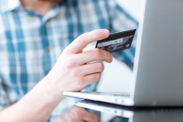 Ο άνθρωπος πραγματοποιεί ηλεκτρονικές αγορές από το φορητό υπολογιστή με πιστωτική κάρτα — Φωτογραφία Αρχείου