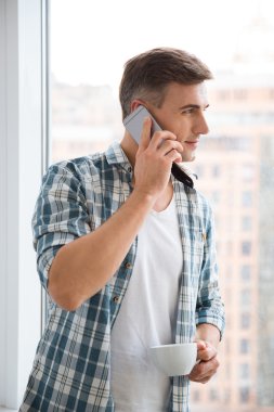 Kahve içme ve telefonda konuşurken çekici adam 