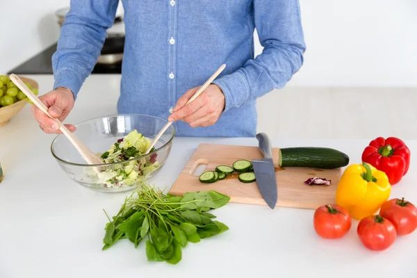 Salada em tigela de vidro feita por macho na cozinha — Fotografia de Stock