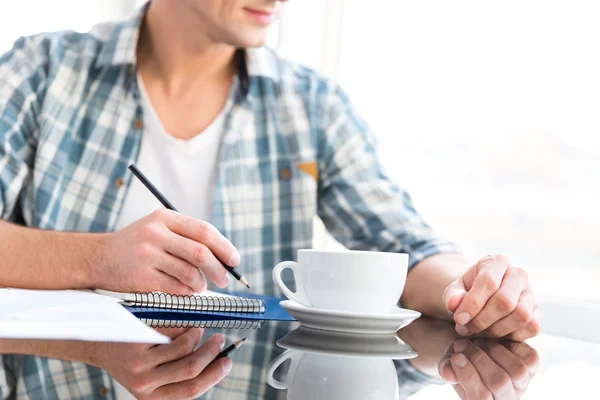Fundersam man rita och dricka kaffe i office — Stockfoto